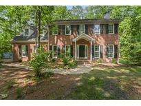 Charming two-story brick home with black shutters and a well-manicured lawn surrounded by mature trees at 4041 Brook Cross Dr, Apex, NC 27539