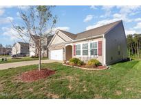 Inviting home exterior featuring stone accents, well-manicured lawn, and attached two car garage at 46 S Great White Way, Clayton, NC 27527