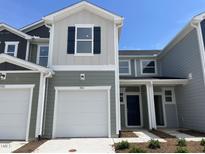 Charming two-story townhouse featuring a one-car garage and neat landscaping under a clear sky at 503 Eastwood St, Durham, NC 27703