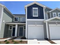 Charming townhome featuring a one-car garage, gray siding, and a classic design with a dark blue accent section at 505 Eastwood St, Durham, NC 27704
