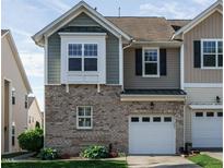 Two-story townhome with brick facade, attached one-car garage, and well-maintained front lawn at 7229 Terregles Dr, Raleigh, NC 27617