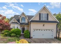 Charming two-story home featuring a well-maintained lawn, a two-car garage, and a classic front facade at 7940 Milltrace Run, Raleigh, NC 27615