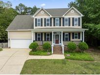 Charming two-story home with a manicured lawn and inviting front porch at 84 N Hadrian Ct, Clayton, NC 27520