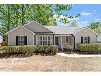 Charming one-story home with gray siding, black shutters, and a well-maintained front lawn at 1021 S Fieldhaven Dr, Fuquay Varina, NC 27526