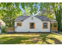 Charming home featuring a new roof and stylish wooden shutters, complemented by a lush green lawn at 1513 Fairfax Rd, Durham, NC 27701