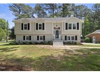 Charming home featuring a well-manicured lawn, updated exterior, black shutters, and a welcoming front entrance at 1532 Cone Ave, Apex, NC 27502