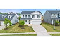 Beautiful two-story home with a well-manicured lawn and a long driveway leading to the garage at 176 Belleforte Park Cir, Garner, NC 27529
