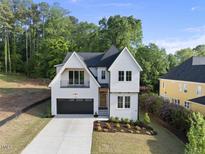Charming two-story home with landscaped yard and a black garage door at 1904 French Dr, Raleigh, NC 27612
