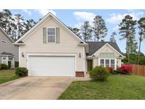 Charming single-story home with a well-manicured lawn, attached garage, and inviting front entrance, exuding curb appeal at 205 Braxcarr St, Holly Springs, NC 27540