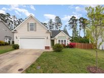 Charming single-Gathering home featuring a well-manicured lawn and attached garage at 205 Braxcarr St, Holly Springs, NC 27540