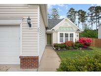 Charming home with a green door, lush landscaping, and inviting curb appeal at 205 Braxcarr St, Holly Springs, NC 27540