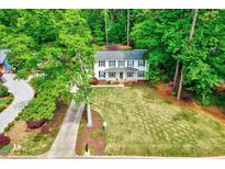 Traditional two-story home featuring a large lawn and surrounded by lush trees at 212 Ronaldsby Dr, Cary, NC 27511