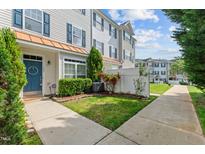 Charming townhouse with tidy front yard, landscaping, and welcoming blue door at 2210 Raven Rd # 105, Raleigh, NC 27614