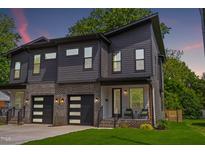 Modern townhome showcasing a striking gray facade, brick accents, and a well-manicured lawn at 2325 Sheffield Rd # 102, Raleigh, NC 27610