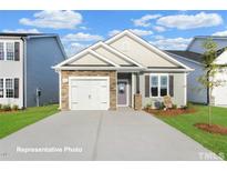 Charming single-story home with stone accents, a two-car garage, and a well-manicured front yard at 245 Bluejay St, Clayton, NC 27520