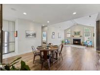 Bright living area boasts hardwood floors, fireplace, vaulted ceilings, and dining area with round table and seating for four at 312 Troon Village Ln, Cary, NC 27511