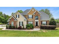Beautiful two-story home featuring brick and siding, mature landscaping, and a well-manicured lawn at 321 Nortwick Rd, Rolesville, NC 27571