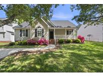 Charming single-story home with a welcoming front porch and lovely landscaping including pink azaleas at 3519 Streams Of Fields Dr, Raleigh, NC 27604
