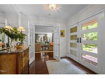 Inviting foyer with hardwood floors, glass-paneled doors, and a view into the bright living room at 3915 Nottaway Rd, Durham, NC 27707