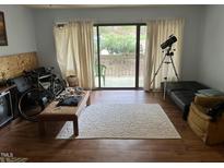 Cozy living room with hardwood floors, a cream rug, sliding glass doors, and a telescope at 500 Umstead # 208D, Chapel Hill, NC 27516