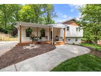 Charming home with a brick facade, covered porch, wooden posts and inviting curb appeal at 5505 Knollwood Rd, Raleigh, NC 27609
