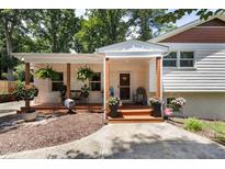 Charming front porch featuring brick facade, wood columns, and beautiful landscaping at 5505 Knollwood Rd, Raleigh, NC 27609