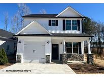 Charming two-story home with white siding, stone accents, and attached one car garage at 57 Goldenrod Loop, Clayton, NC 27520