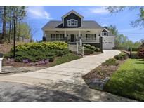 Charming two-story home with a welcoming front porch and well-manicured landscaping and long driveway at 629 Houndsditch Cir, Wake Forest, NC 27587