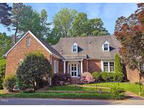 Charming brick home with well-manicured lawn, mature trees and manicured shrubbery enhancing the curb appeal at 8 Greenside Ct, Durham, NC 27707