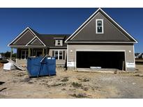 New construction two-story home showing siding and garage, with a large blue trash bin in the front at 835 Olive Branch Dr, Smithfield, NC 27577