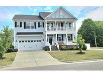 Charming two-story home featuring a welcoming porch, attached garage, and well-manicured lawn at 1002 Dogwood Bloom Ln, Knightdale, NC 27545