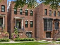 Charming brick townhome featuring a landscaped front yard and inviting entrance staircase at 1027 S Duke St, Durham, NC 27707