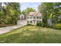 Charming two-story home with green shutters, a lush lawn, and an attached two-car garage at 105 Bergeron Way, Cary, NC 27519