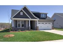 Charming two-story home featuring a well-manicured lawn, gray siding, and brick accents at 1091 Fairhaven Dr # 47, Mebane, NC 27302