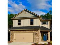 Two-story home featuring a brick facade, a two-car garage, complementary siding and a vibrant blue front door at 114 High Hampton Way, Fuquay Varina, NC 27526