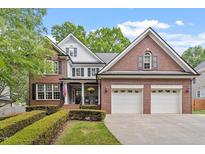 Charming brick home with a manicured lawn and an attached two-car garage at 121 Cobblepoint Way, Holly Springs, NC 27540
