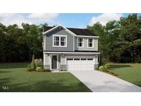 Charming two-story home featuring a gray exterior, complemented by a lush green lawn and a spacious two-car garage at 131 Vulcan St, Garner, NC 27529