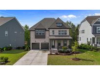 Charming two-story home with brick facade, covered front porch, and well-manicured lawn at 1632 Ferntree Ct, Morrisville, NC 27560