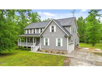 Charming two-story home with gray siding, white trim, front porch, and well-maintained landscaping at 179 Carrie Dr, Archer Lodge, NC 27527
