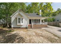 Charming one-story home with white siding, covered porch and beautiful landscaped front yard at 2028 Ruddy Rd, Raleigh, NC 27616
