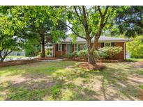 Charming brick home with mature trees and a well-manicured lawn at 209 N Occoneechee St, Hillsborough, NC 27278