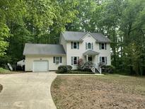 Charming two-story home with landscaped yard, attached garage, and lovely curb appeal surrounded by mature trees at 3648 Sleepy Hollow, Wake Forest, NC 27587