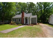 Charming one-story home featuring a brick chimney, walkway, and well-manicured lawn at 408 E Maynard Ave, Durham, NC 27704