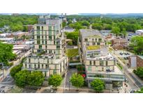 Stunning aerial view of a modern multi-story condominium complex with beautiful landscaping and rooftop terraces at 601 W Rosemary St # 905, Chapel Hill, NC 27516