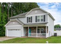Charming two-story home featuring stone accents and a covered front porch at 71 Hunters Way, Angier, NC 27501