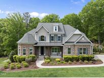 Beautiful two-story home with stone accents, a covered front porch, and manicured landscaping at 7517 Summer Pines Way, Wake Forest, NC 27587
