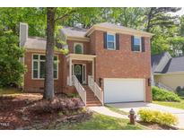 Charming brick home featuring well-manicured landscaping and an attached two-car garage at 8124 Greywinds Dr, Raleigh, NC 27615