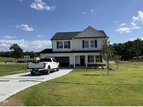 Charming two-story home with a well-maintained lawn and a white truck in the driveway at 10 Silver Ct, Smithfield, NC 27577