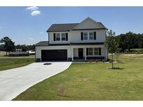 Charming two-story home featuring a black two-car garage and a well-manicured lawn on a sunny day at 10 Silver Ct, Smithfield, NC 27577