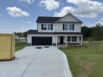 Charming two-story home featuring a black garage door, a well-manicured lawn, and black shutters at 10 Silver Ct, Smithfield, NC 27577